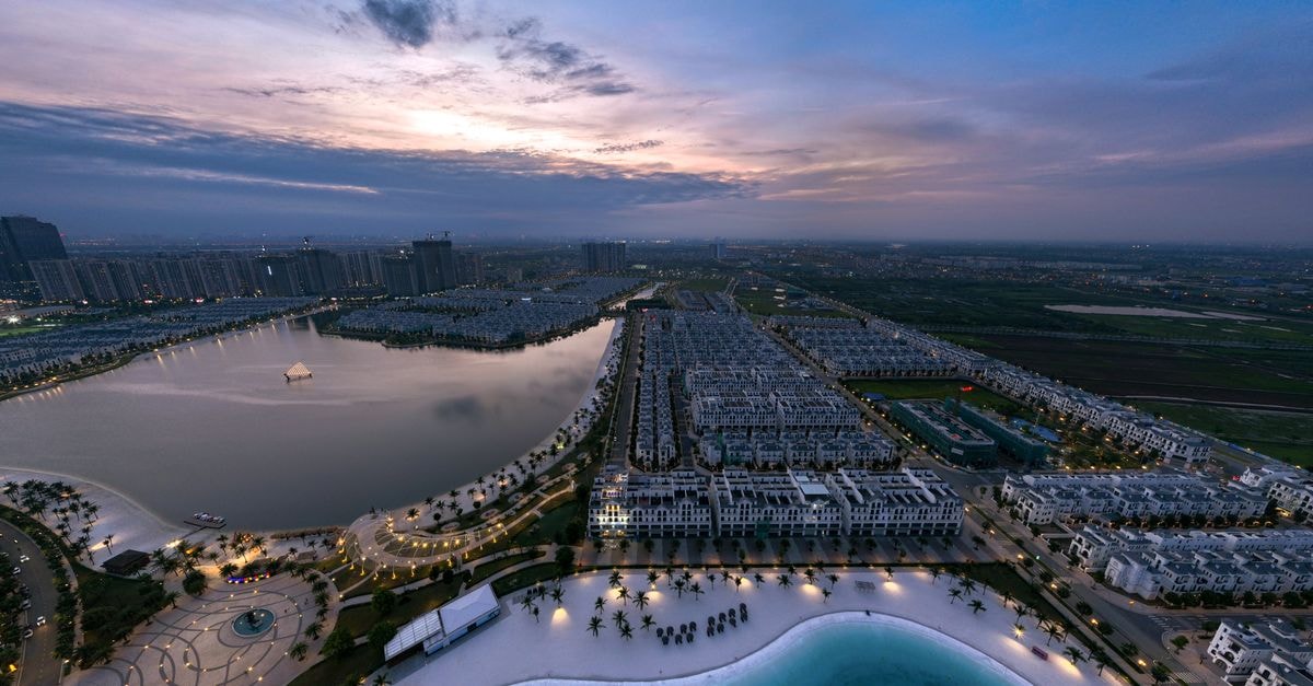 Khách sạn Mekong Mỹ Tho: Modern Mekong Riverside Stay in the City Center Stunning aerial view of Vinhomes Ocean Park in Hanoi during sunset, showcasing urban landscape and tranquil water bodies.