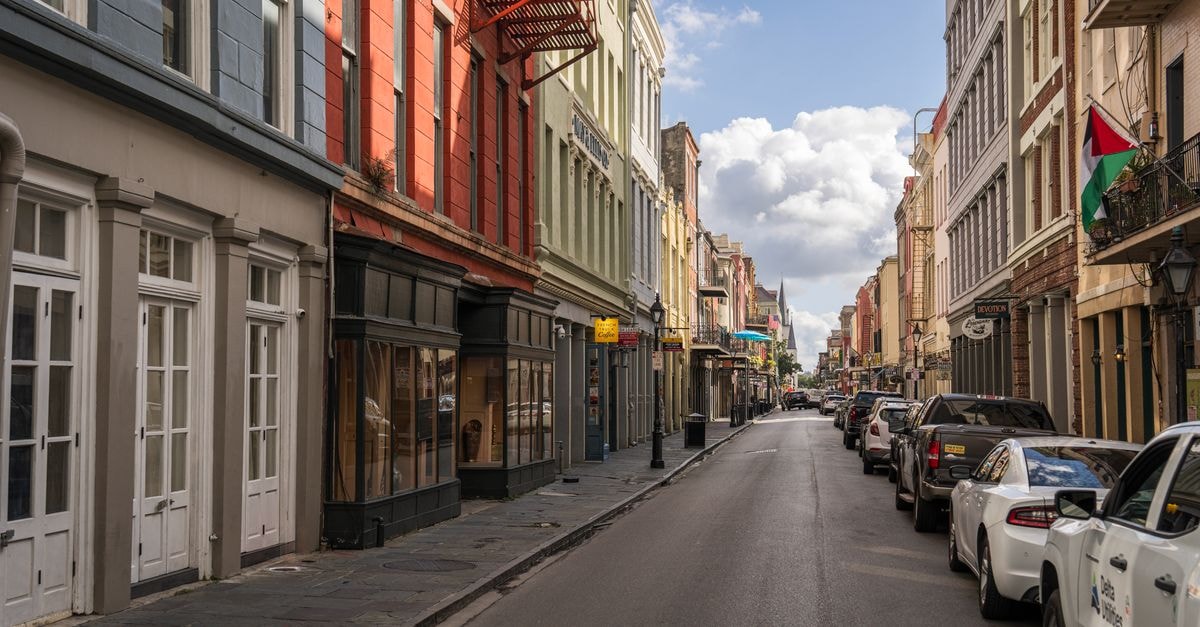 Vibrant street scene in New Orleans featuring historic buildings and parked cars.