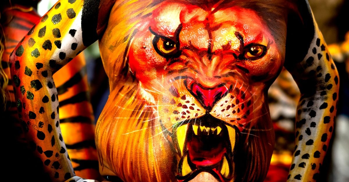Hotel in Thrissur, India — A Modern Stay in a Storied City Close-up of painted body featuring a lion face, vibrant body art from Thrissur, India festival.