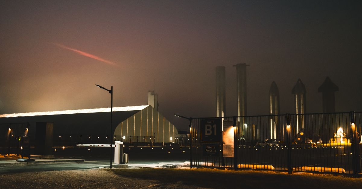Dramatic night view of SpaceX facility with fog and lights in Brownsville, Texas.