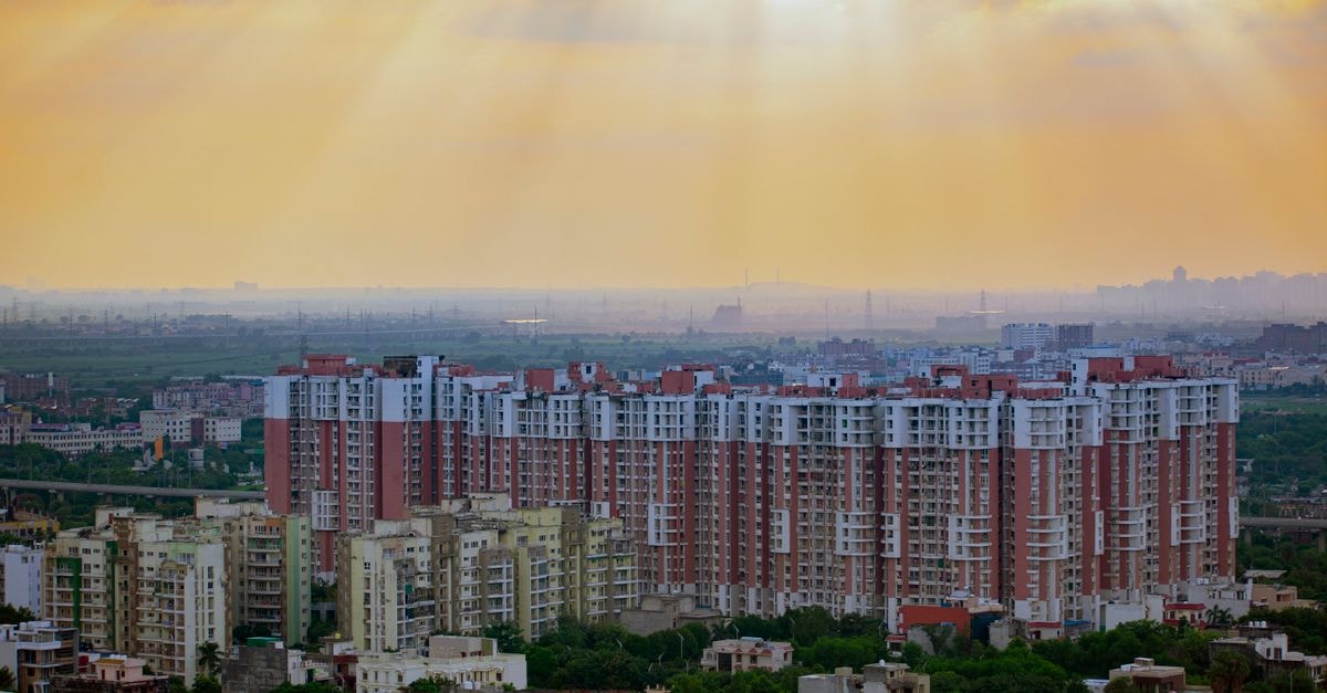 Country Inn and Suites, Ghaziabad: A Sahibabad Address Worth Knowing Captivating aerial view of Noida's residential skyline at sunrise, showcasing modern architecture and dramatic skies.