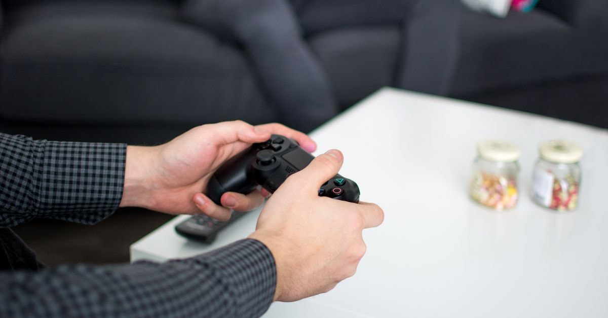 SteamOS Beta 加入無線轉接器支援,預示 Steam Frame 即將推出 雙手握持遊戲手把的特寫,呈現客廳環境中的休閒活動。