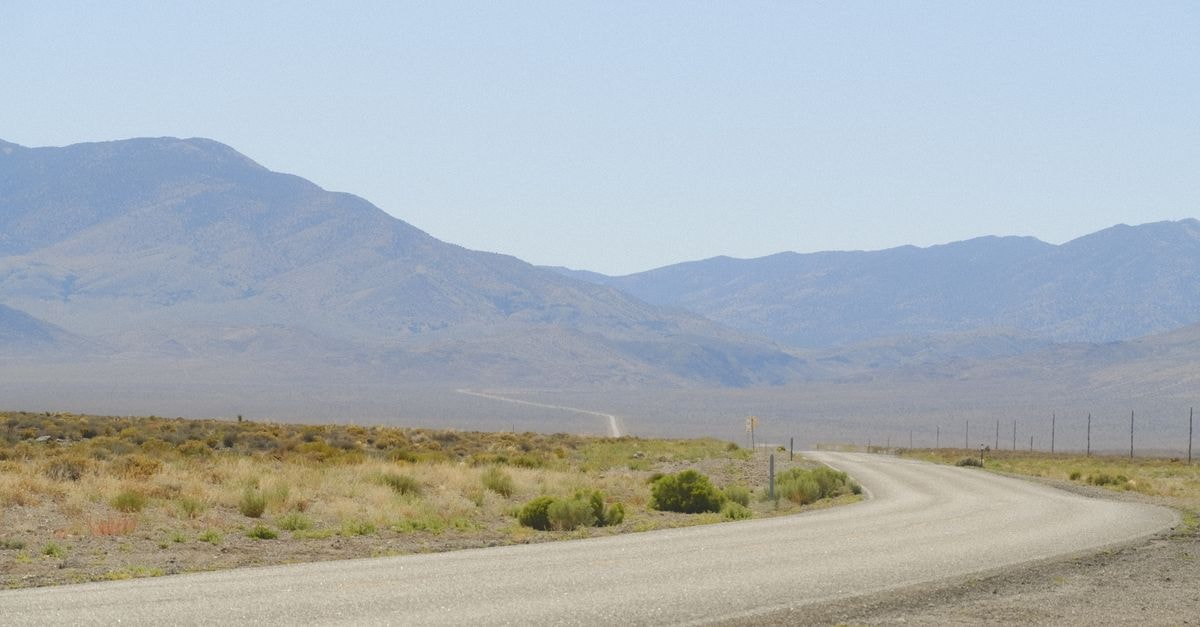 Henderson, Nevada Travel Guide: Arts, Highways, and a Growing Food Scene Wide open desert road showcasing the vast Nevada landscape with mountains in the background.