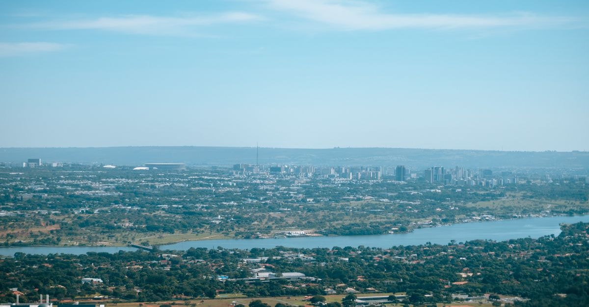 Aerial cityscape with skyline and river under clear blue sky.