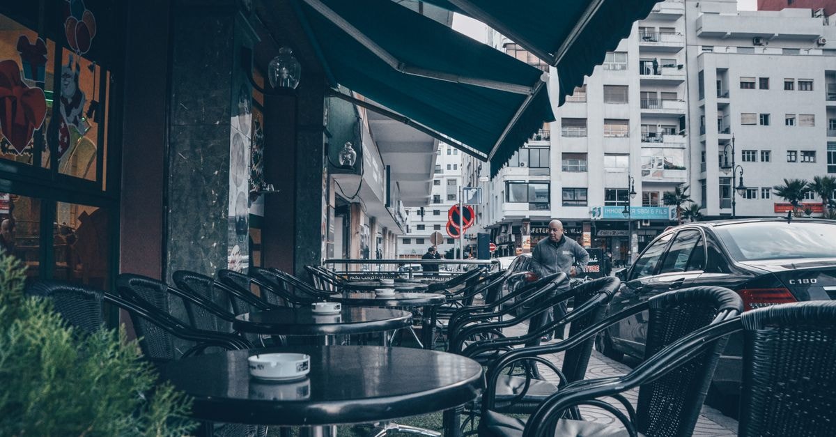 Algiers Travel Guide: Planning Tips, Costs and Things to Do Charming outdoor cafe with wicker chairs and tables under a canopy in bustling Tangier, Morocco.