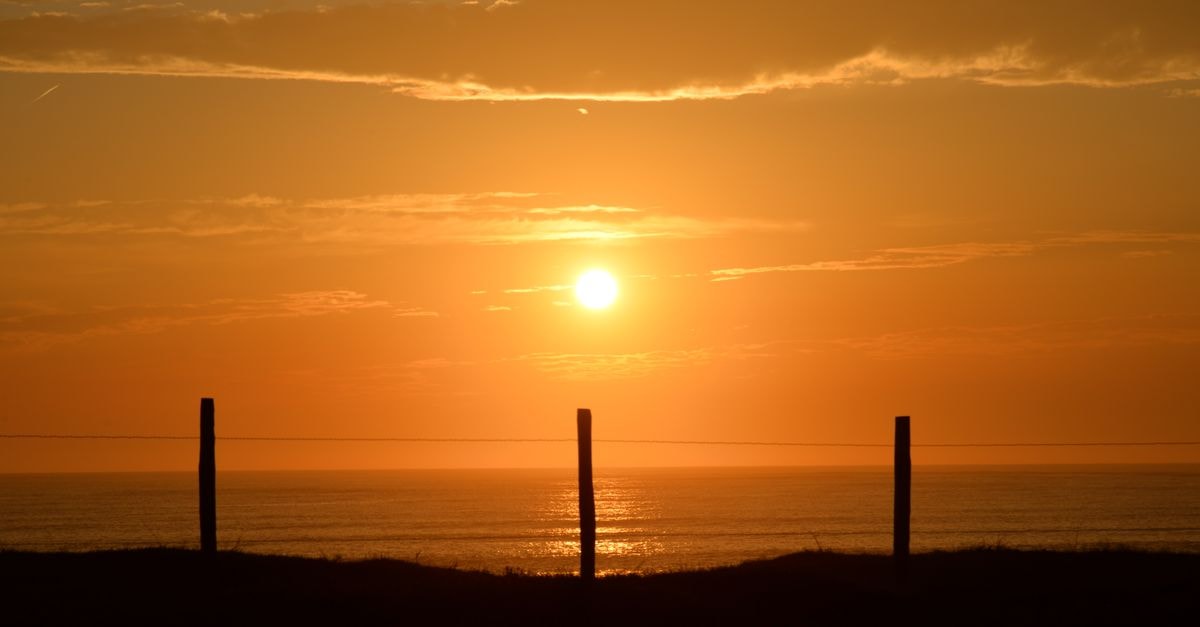 Breathtaking sunset over the Atlantic Ocean at Saint-Vincent-sur-Jard, with silhouettes of fencing.