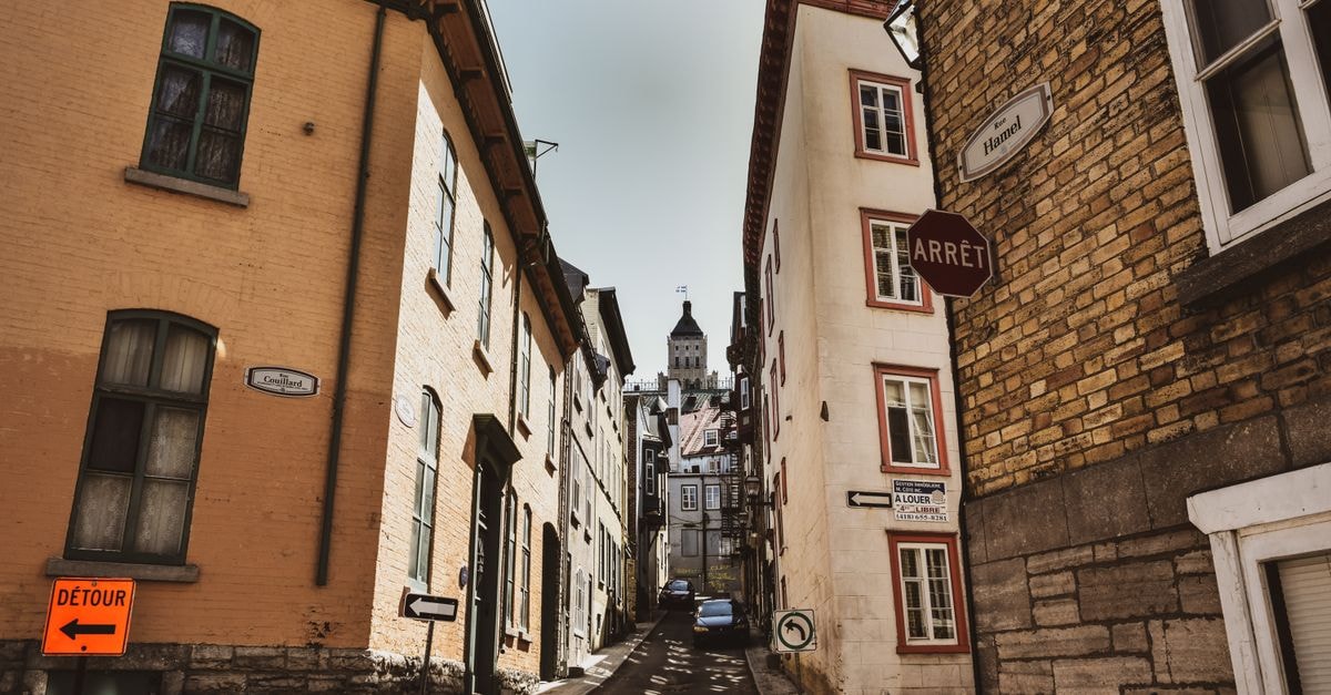 Quaint alleyway in Quebec City with historic architecture under a clear sky.