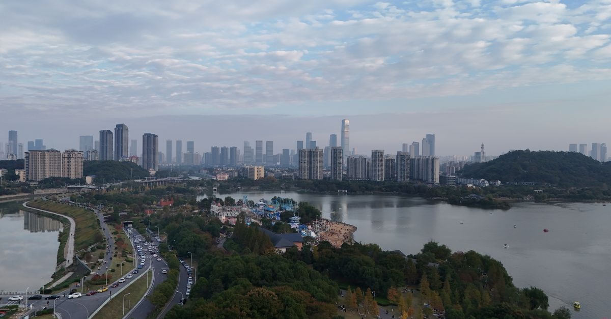 Ascott Central Wuxi in Wuxi: Heart-of-City Serviced Apartments Near Markets and Temples Aerial view of Changsha skyline with river and park during the day.