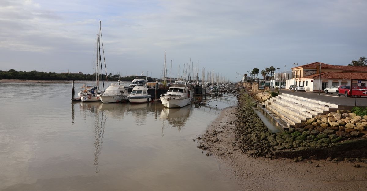 Puerto Francisco de Orellana Travel Guide: Planning Tips, Costs and Things to Do A serene scene of boats moored along the riverbank in El Puerto de Santa María, Andalucia, Spain.