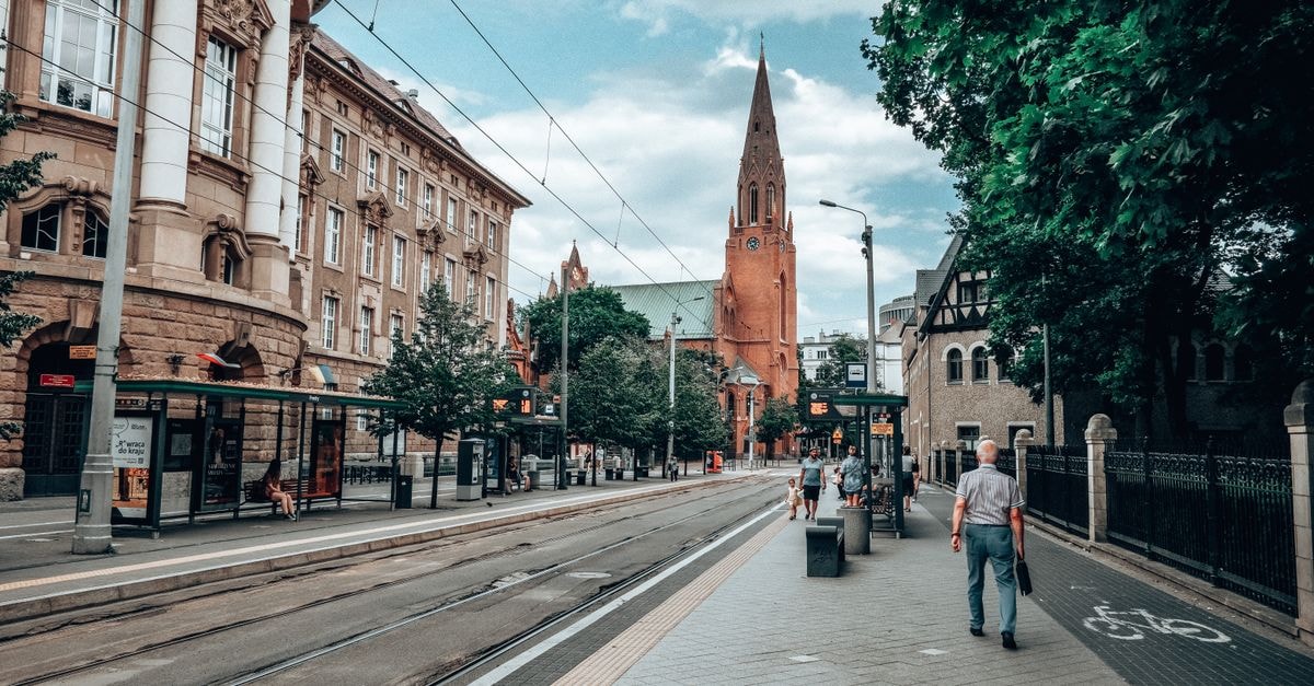 Gorzów Wielkopolski Travel Guide: Planning Tips, Costs and Things to Do A street view in Poznań, Poland, featuring historic buildings, a tramway, and a church.