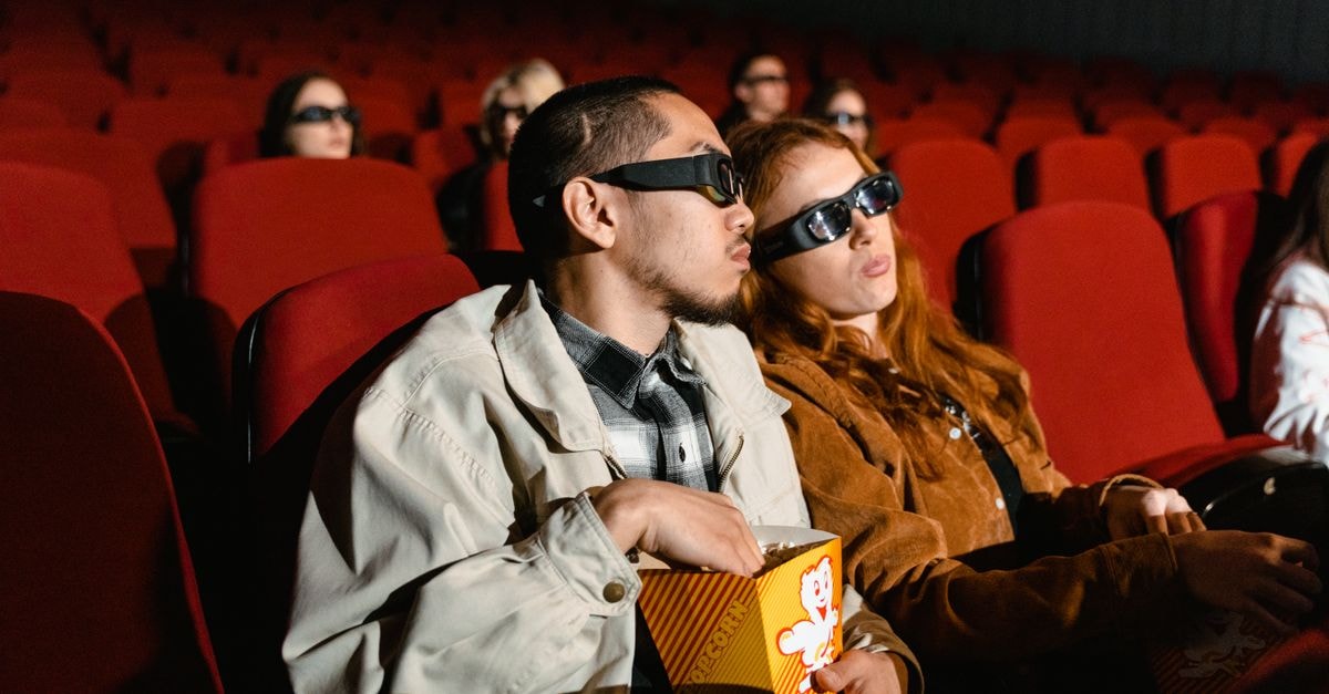 Analog Devices Director Karen Golz Sells $374,500 in Stock Under 10b5-1 Plan Couple wearing 3D glasses watching a movie in a cinema, enjoying popcorn.