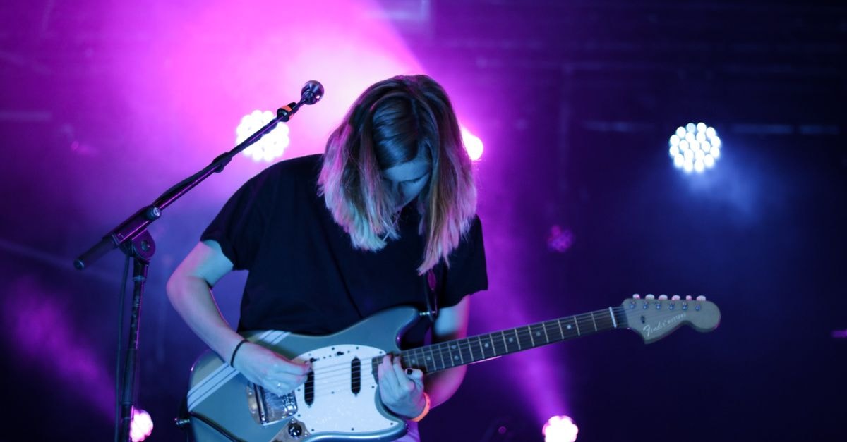 Cursive debut "Wounded Animal" from Tim Kasher's Who's Watching soundtrack A captivating guitarist performs in vibrant lighting at a live concert in Breda, Netherlands.