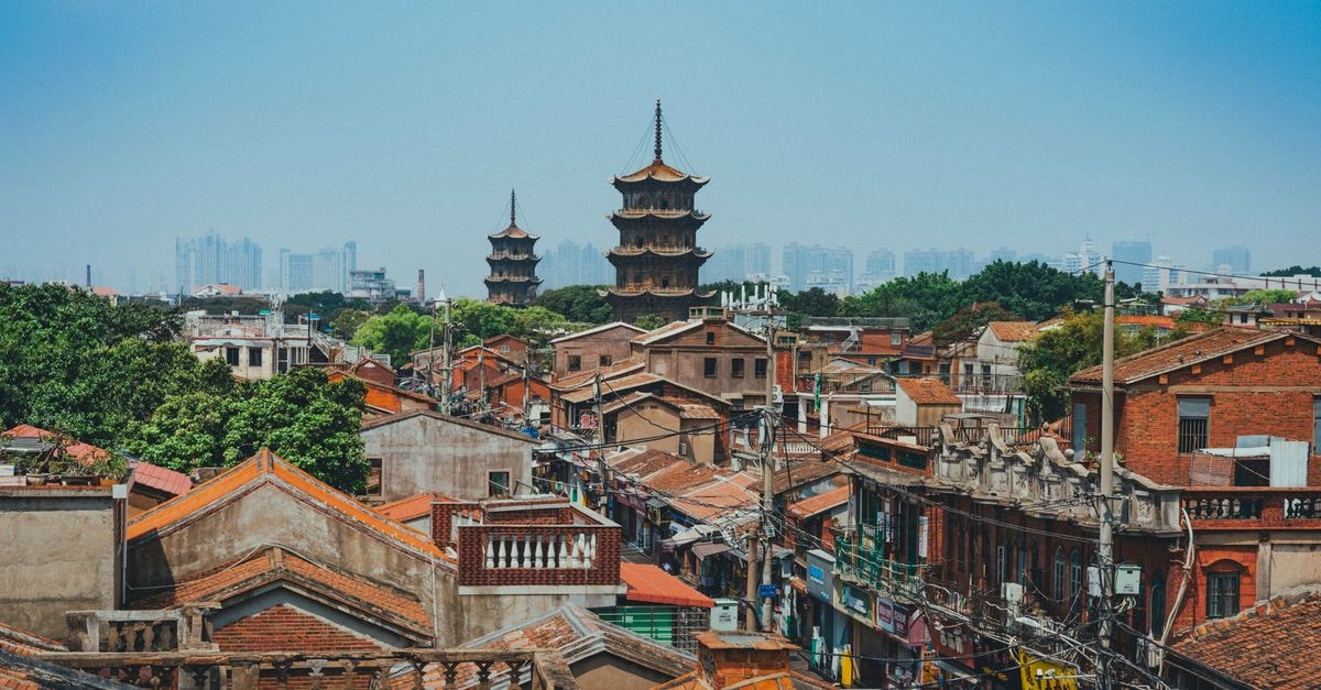Slow Days in Quanzhou: A Travel Guide to China's Seaport Heritage City A scenic view of Quanzhou's traditional rooftops and iconic pagodas against a modern skyline.