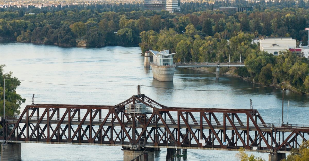Hilton Garden Inn Saskatoon Downtown, Saskatoon — A Downtown High-Rise on 22nd Street East Aerial view of the scenic train bridge and river in Sacramento, California, surrounded by lush foliage.