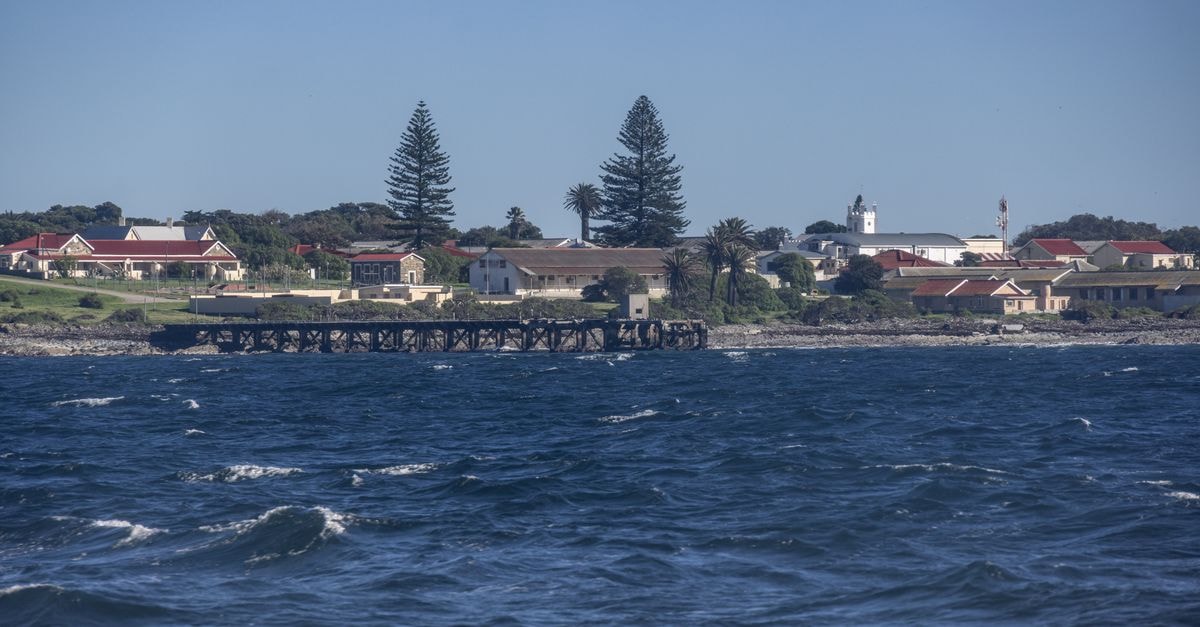 The Delight Swakopmund in Swakopmund: A Fresh Breeze on the Atlantic Coast Picturesque view of a coastal town with a pier and ocean waves under a clear blue sky.