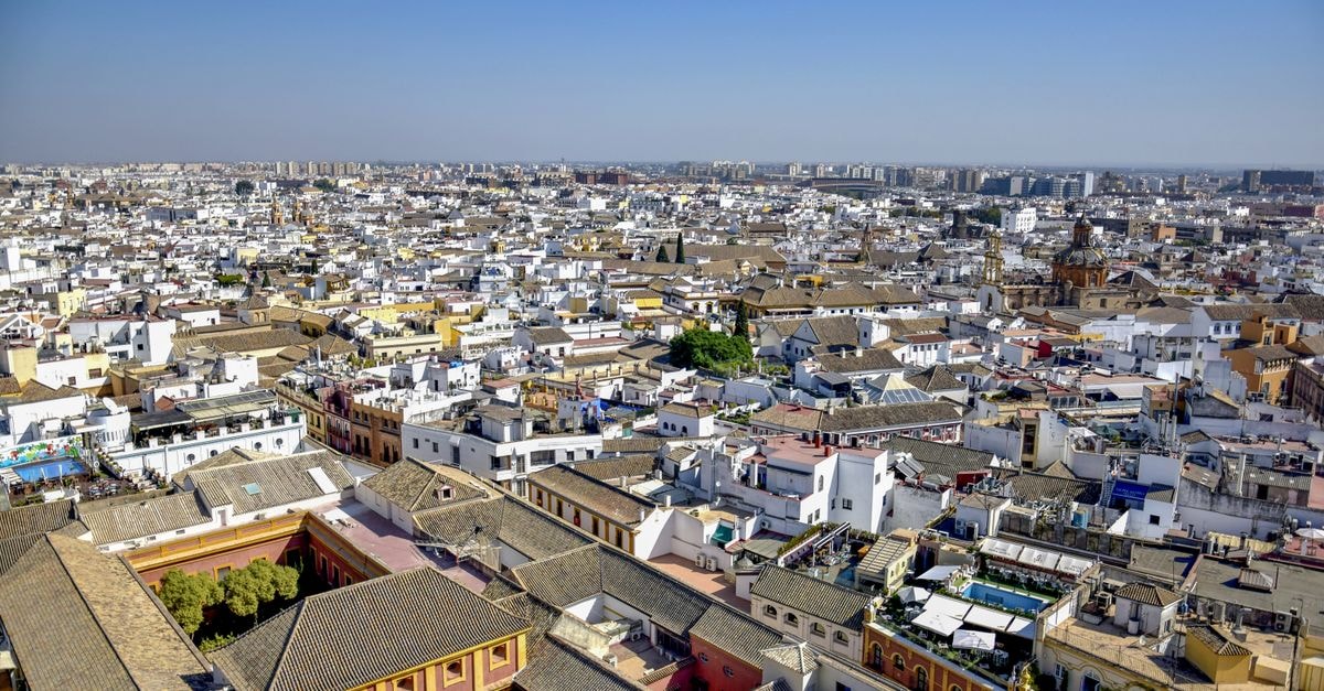 Breathtaking aerial view of Seville showcasing traditional Spanish architecture under a clear blue sky.