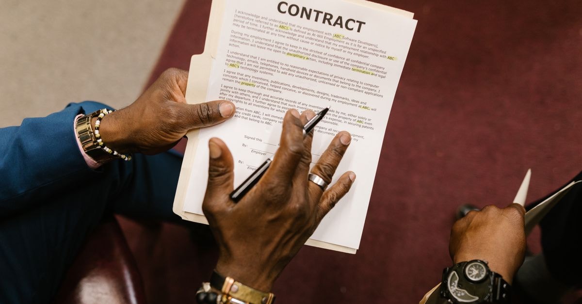 Caterpillar commits $3M to Arkansas workforce training under five-year $100M initiative Two businessmen reviewing and signing a contract document in an office setting.
