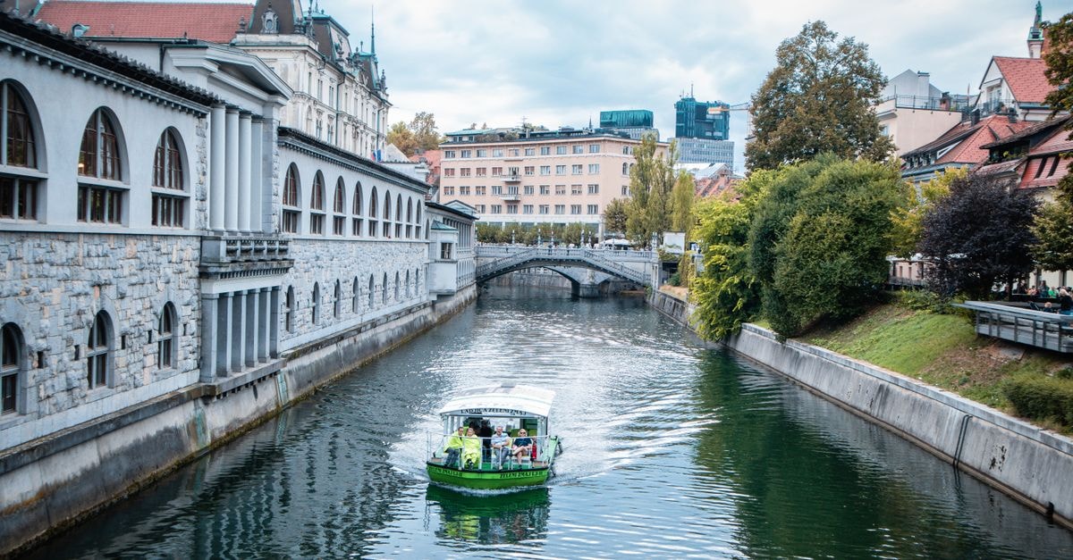 Explore a scenic view of a canal with a boat in Ljubljana, Slovenia.