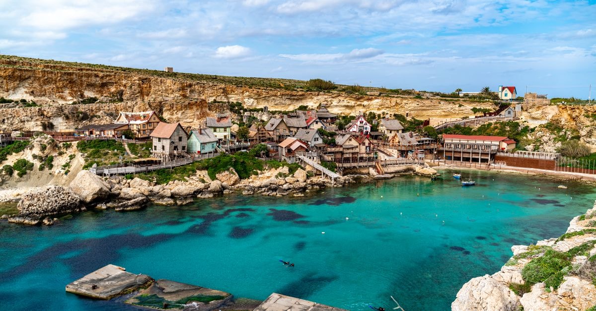 Things to Do in Attard: A Quiet Malta Village Guide Picturesque view of Popeye Village with azure waters and coastal cliffs in Malta. Perfect travel destination.