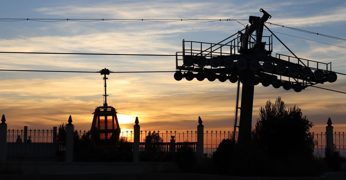 Hôtel Grand Bassin in Tlemcen: Views Over the Grand Bassin Park A silhouette of a cable car against a vibrant sunset sky in Tlemcen, Algeria.