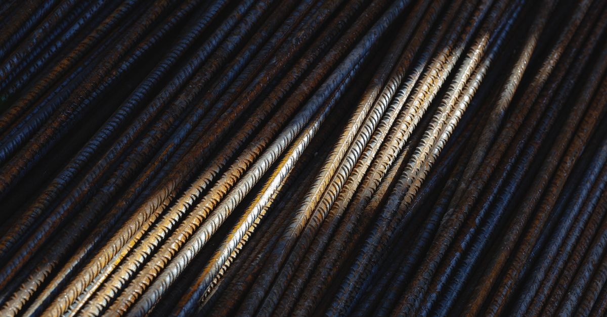 Tata Steel flags easing Indian rebar prices as Japan's Kyoei Steel holds August quotes Artistic close-up of rusty steel rebars with dramatic lighting and texture.