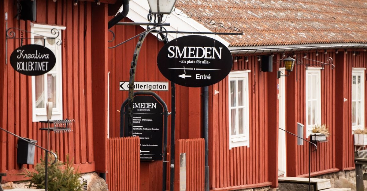 Traditional red wooden house with signage in Huskvarna, Jonkoping County, Sweden.