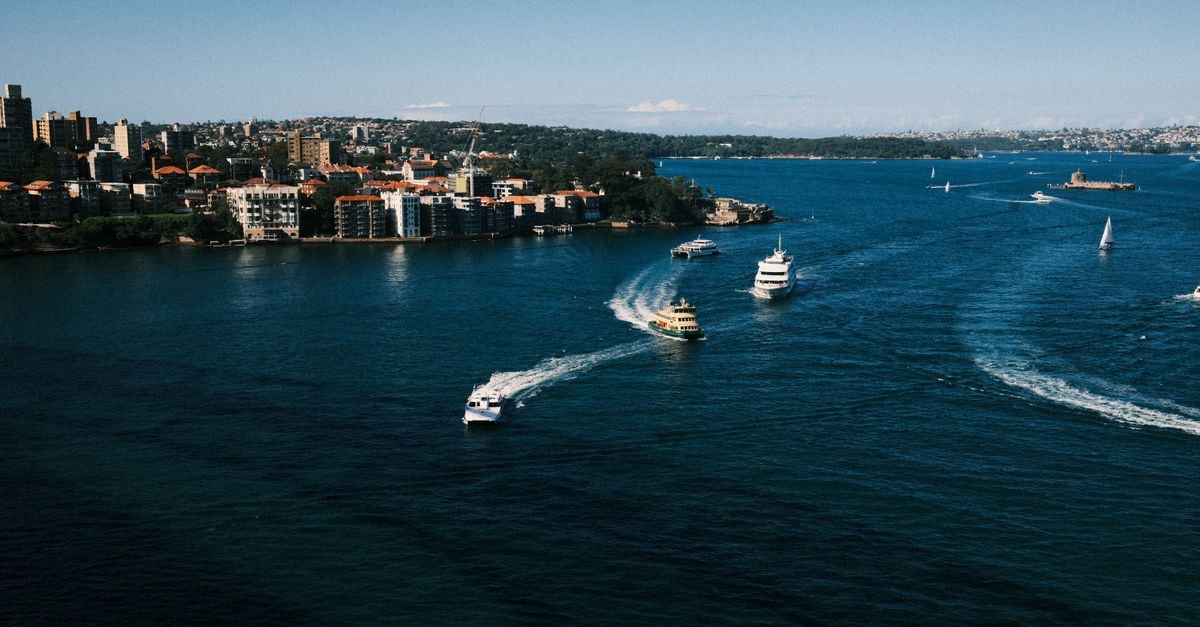 Tu Isla in Nueva Gerona: A Calle 24 House with a Rooftop Terrace Scenic view of boats cruising through Sydney Harbour with cityscape in the background.