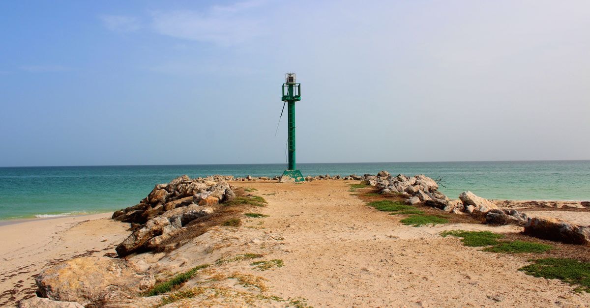 A serene breakwater leading to a beacon by the turquoise ocean in Chuburná, Yuc., Mexico.