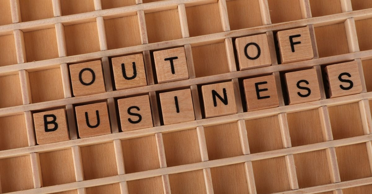 Wooden blocks spelling 'Out of Business', conveying closure or financial difficulties.