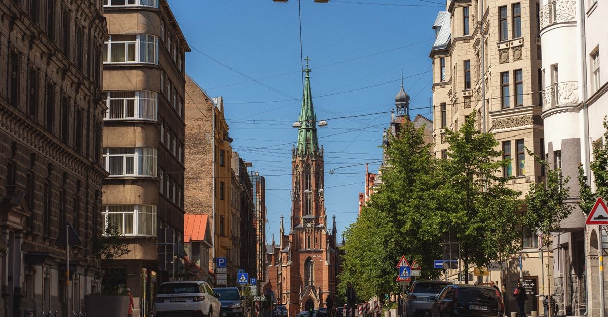 Rixwell Old Riga Palace Hotel, Riga — Art Nouveau Stay on a Quiet Old Town Street A picturesque street view of St. Gertrude Old Church in Riga, Latvia on a sunny day.