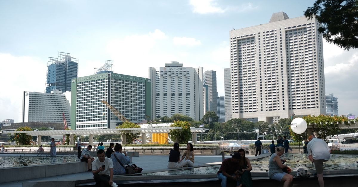 Woodlands, Singapore Travel Guide: Waterfront Strolls and Hawker Bites Discover the vibrant cityscape of Singapore with people enjoying the sunny day outdoors.