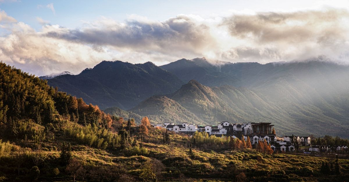 Huaibei Travel Guide: A Quiet Northern Anhui Discovery Beautiful mountainous landscape with a scenic village in Anhui, China under a cloudy sky.