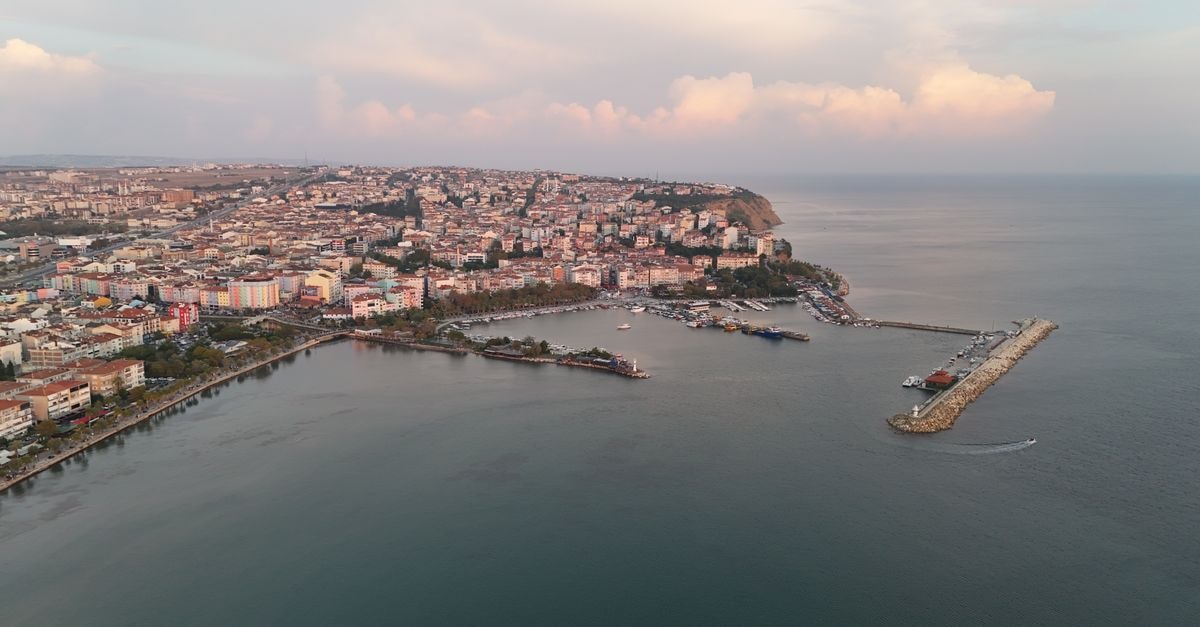 Bagcilar Travel Guide: Planning Tips, Costs and Things to Do A picturesque aerial view of a coastal city and harbor at dusk.