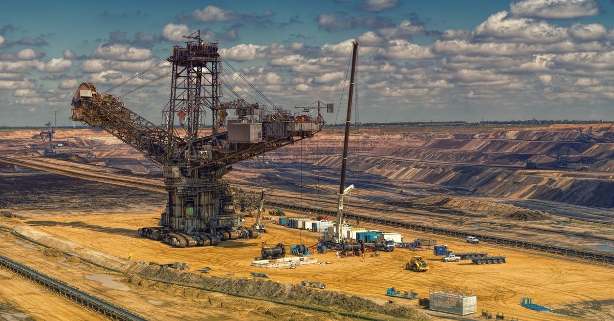 Major copper miners report strong results as Ivanhoe turns profitable and Glencore lifts H1 output Aerial view of heavy machinery operating in a vast open-pit mine under a cloudy sky.