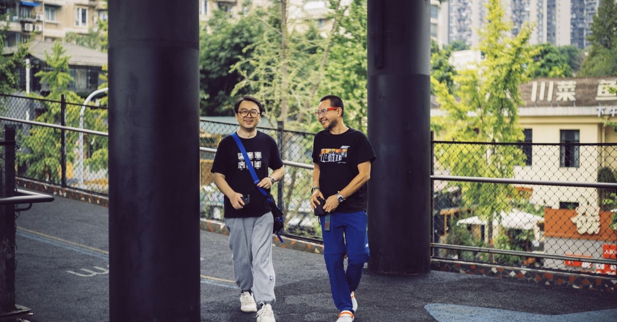 Lyhn International Hotel, Chengdu — Heart of Chunxi Road Shopping Two men enjoying a walk in Chengdu, China, amidst an urban backdrop.