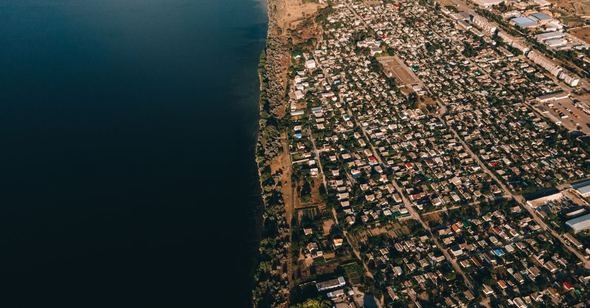 Betio Lodge in Betio, Tarawa: An 18-Room Base Near WWII History Aerial view of a coastal town next to the ocean, showcasing urban architecture and nature.
