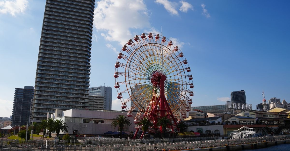 Oriental Hotel Kobe: Heritage Stay in a Foreign Settlement Landmark Scenic view of Kobe's iconic Harborland Ferris Wheel on a sunny day.