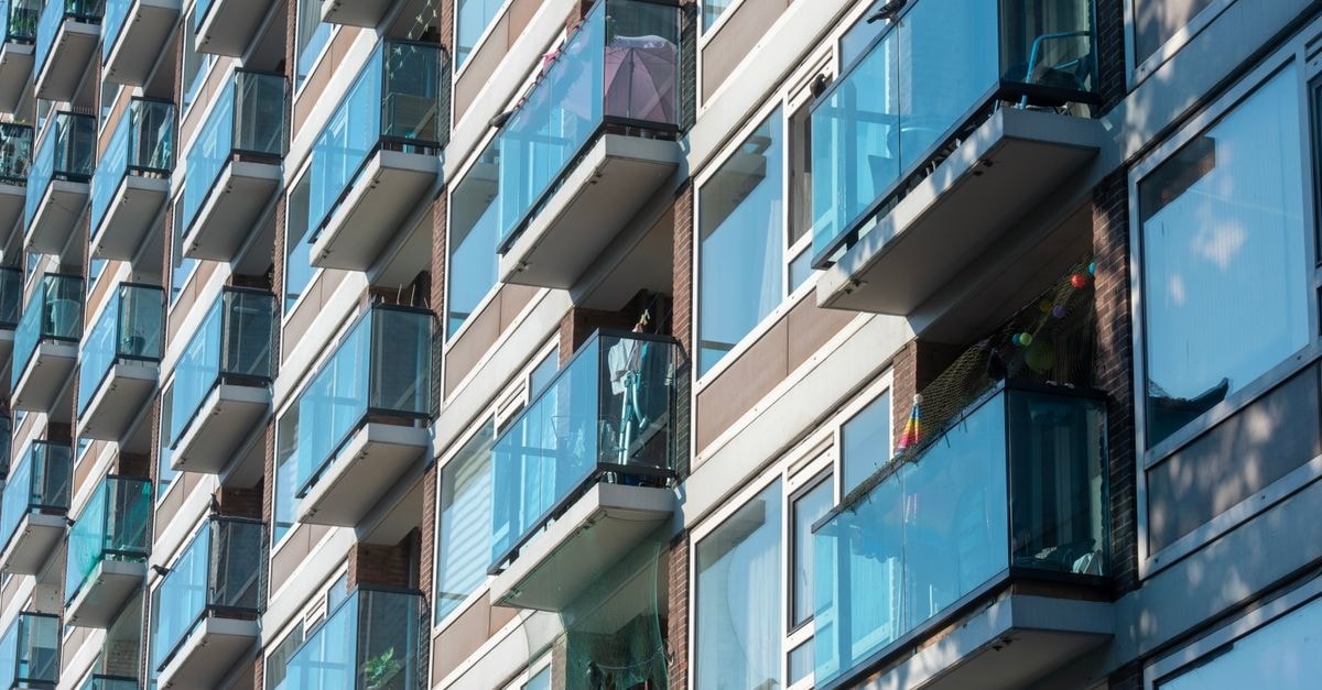 Close-up view of a modern apartment facade with glass balconies in Delft, Netherlands.