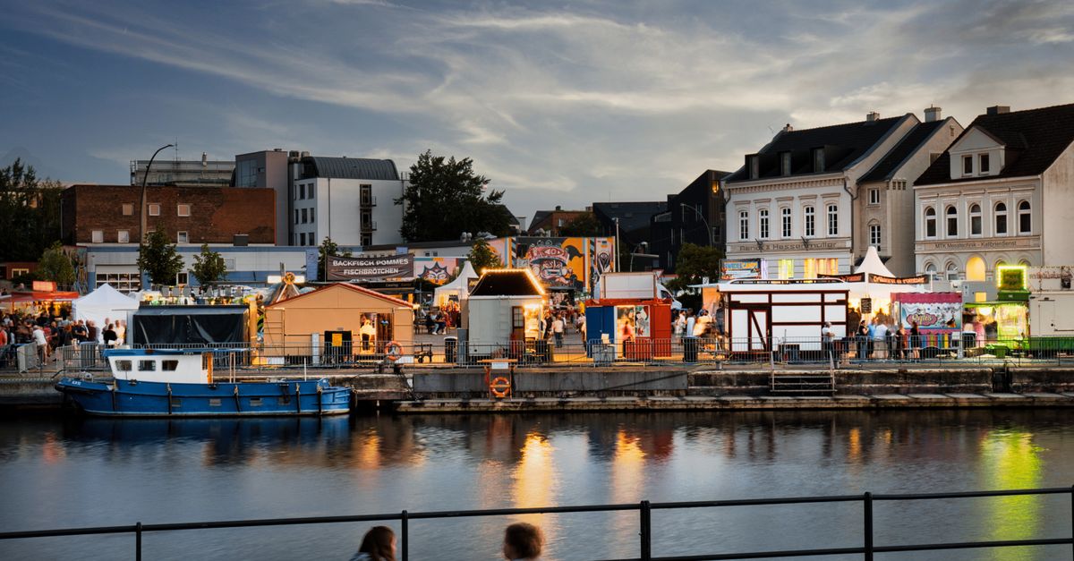 Things to do in Turku in July 2026: festivals, ferries, and food along the Aura River Busy evening market by the water with vibrant stalls and reflections.