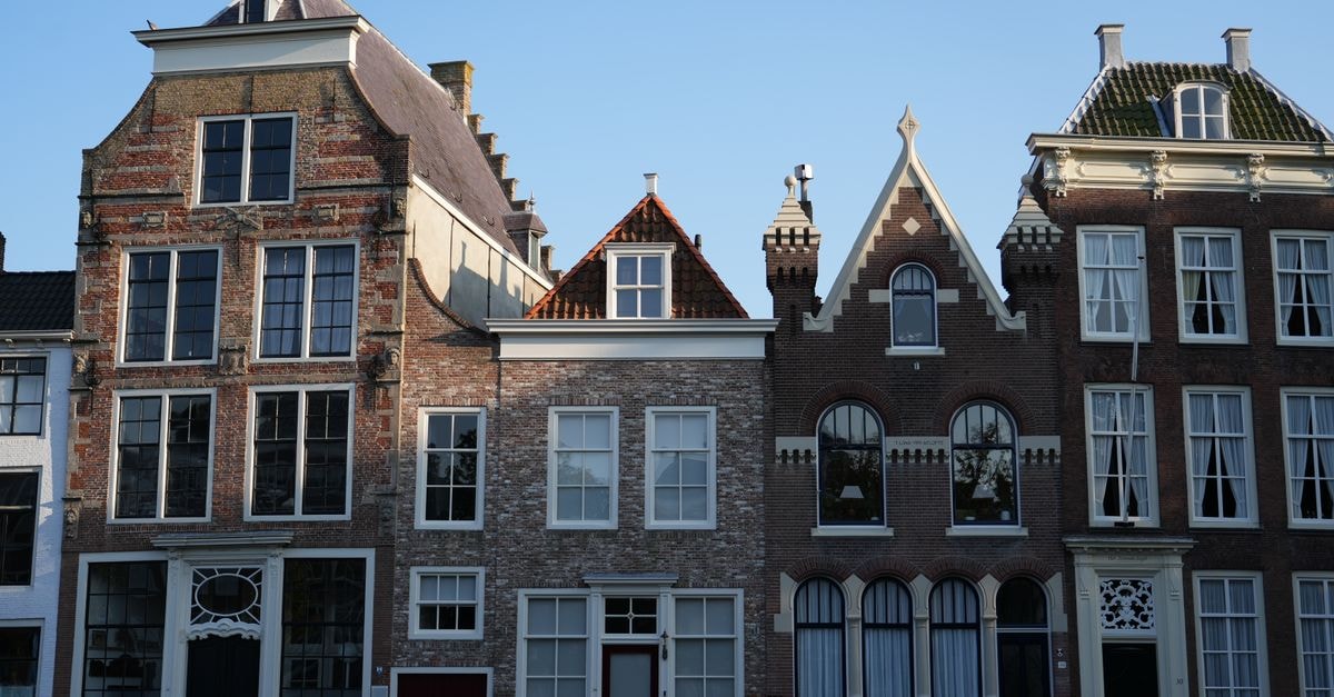 Middelburg Travel Guide: A Slow Weekend in Zeeland's Capital Charming canal houses in Middelburg, Netherlands, showcasing classic Dutch architecture under a clear sky.