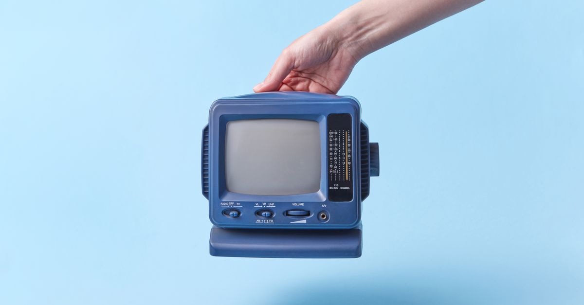 MTV and Paramount+ Renew RuPaul's Drag Race Franchise for New Seasons A hand holding a vintage blue CRT television against a light blue background. Studio shot.