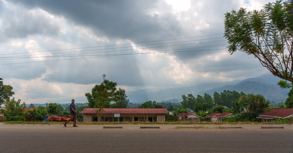 Mzuzu Travel Guide: Northern Malawi's Highland Gateway A serene rural scene in Uganda featuring a road, houses, and dramatic cloudy skies.