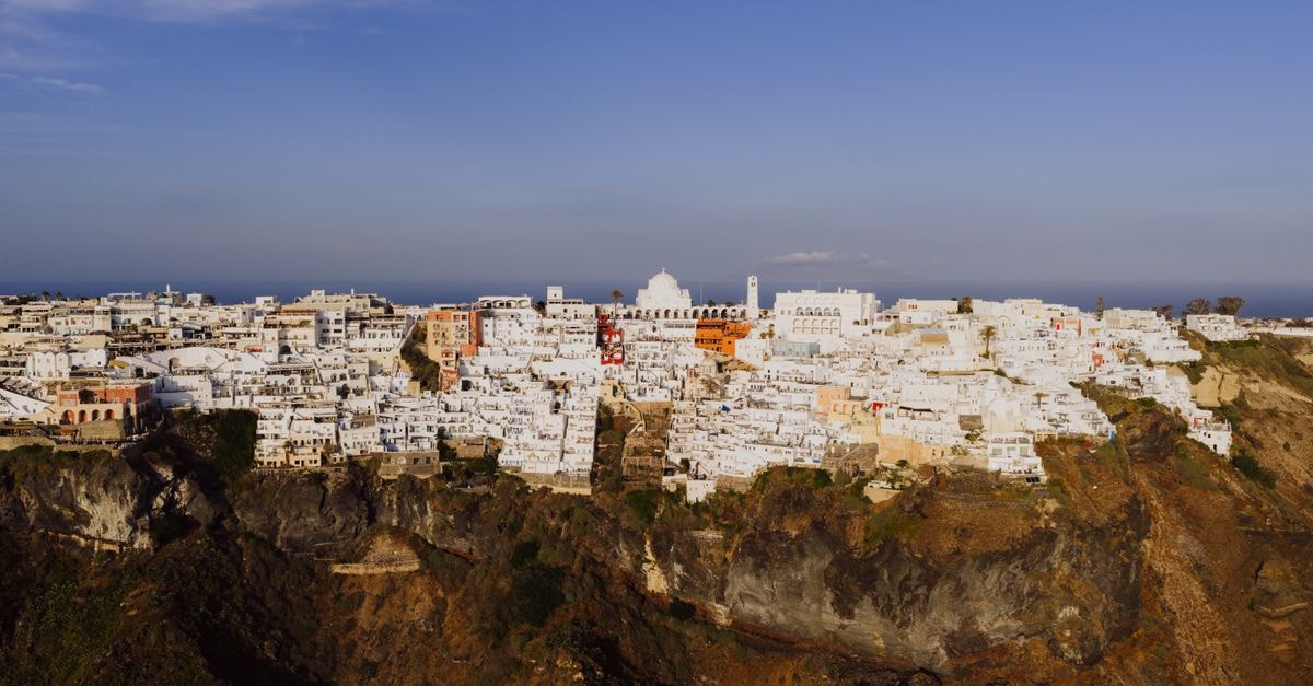 Aressana Spa Hotel and Suites in Fira: A Quiet Cycladic Retreat in Santorini’s Capital Beautiful aerial view of iconic white buildings on cliffs in Fira, Santorini, Greece.
