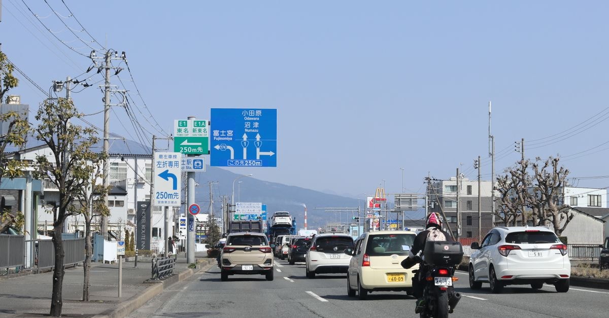晴朗天空下，靜岡清水市區車輛與交通號誌的街景。