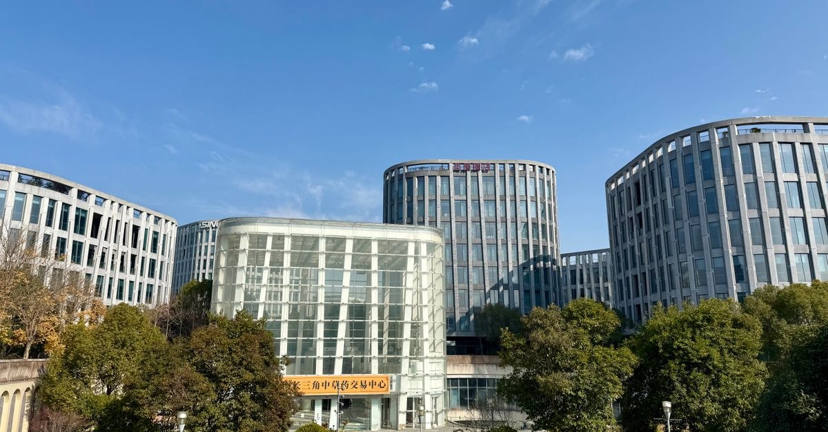 Contemporary office buildings framed by lush greenery in sunny Zhangjiang, Shanghai.
