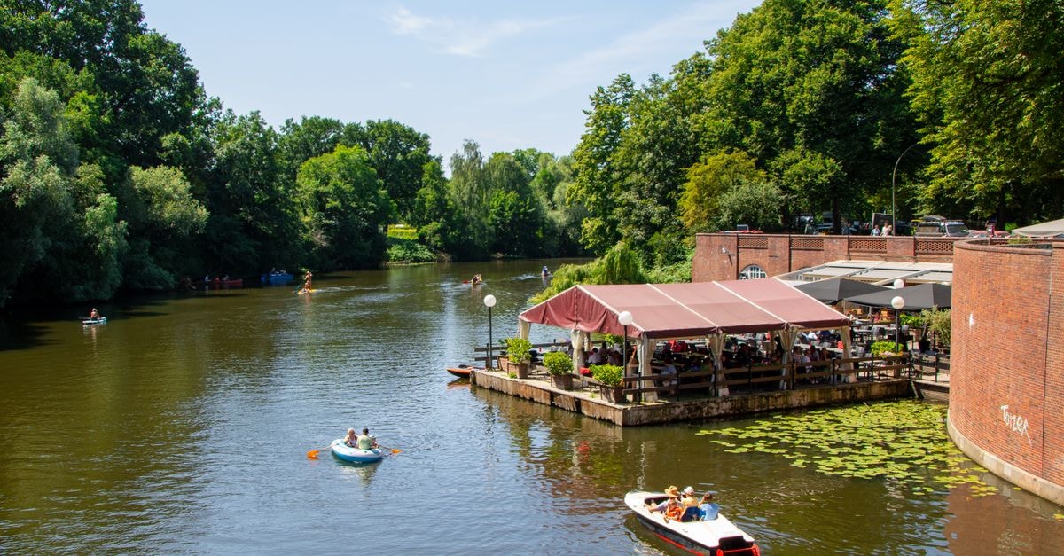 People enjoying a summer day at a canal-side café in Hamburg, Germany.