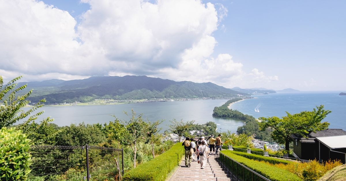 Explore the picturesque Amanohashidate sandbar in Miyazu, Kyoto, Japan, surrounded by lush greenery and serene waters.