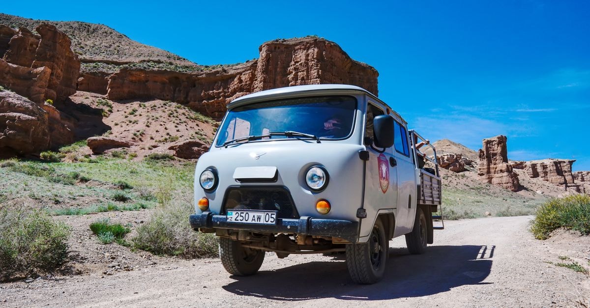 Montana Hotel in Van: A 40-Room Stay on Kazım Karabekir Boulevard A retro van travels through the rugged landscape of Charyn Canyon, Kazakhstan, under a clear blue sky.