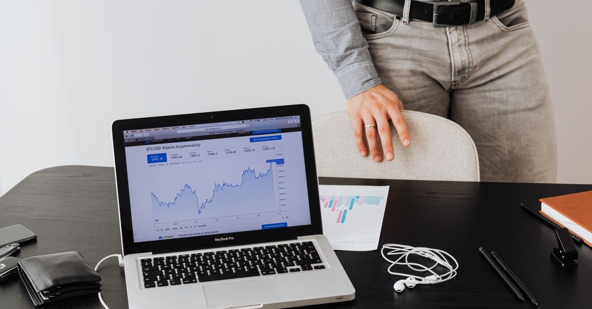 Flputnam and S&CO Acquire New Stakes in Procter & Gamble A businessman stands next to a laptop displaying cryptocurrency data, symbolizing modern digital finance.