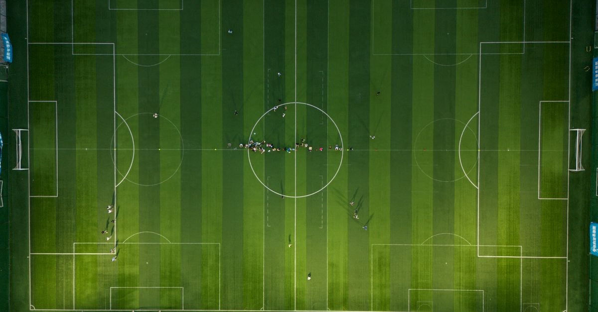 Yomif Kejelcha Sets Half Marathon World Record in Buenos Aires Top-down view of a soccer field with players during daytime.